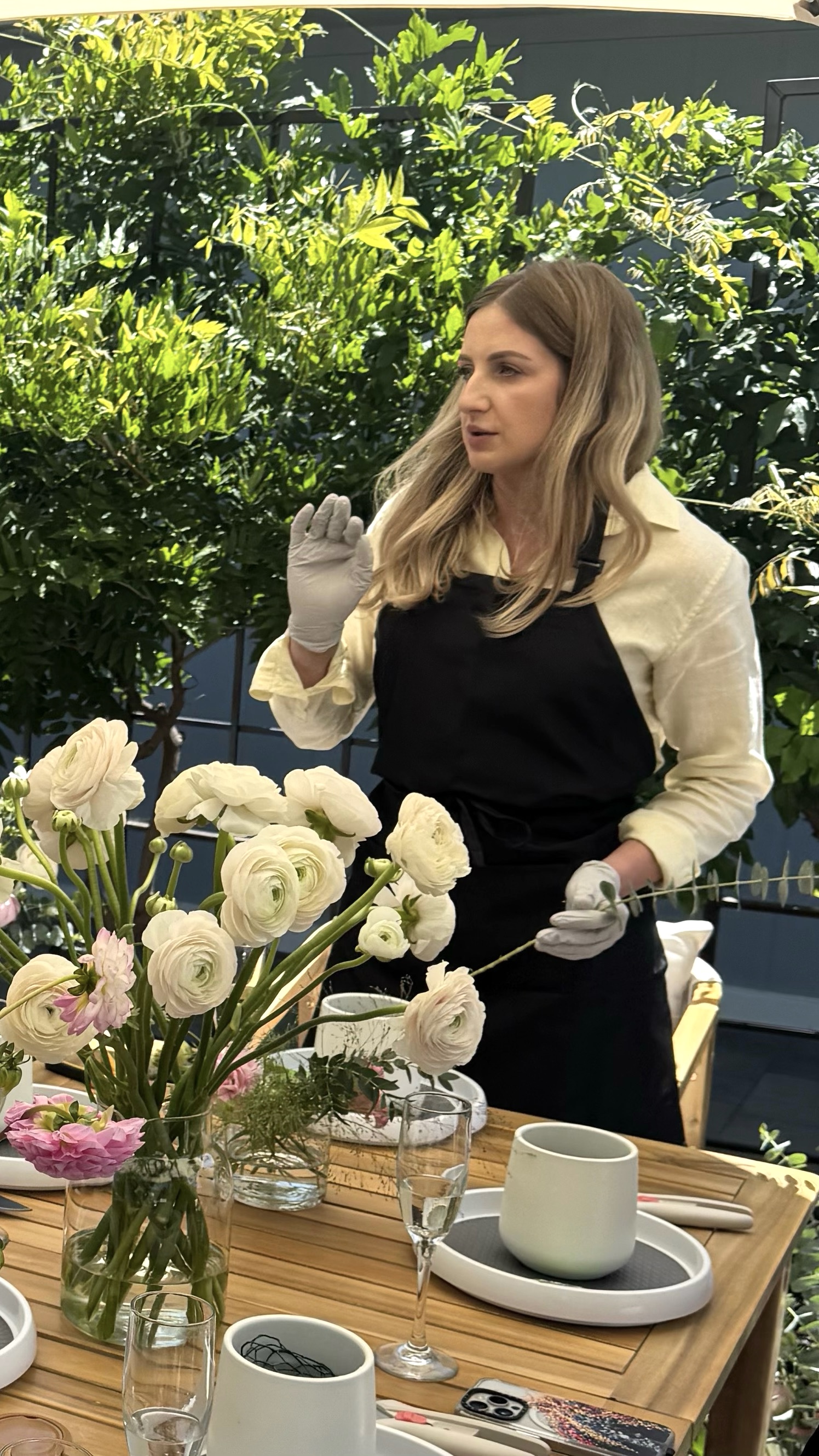 Anna teaching a floral workshop with white ranunculus in the foreground